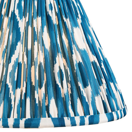 Close-up of Endon Brenwell 30cm tapered lamp shade in Marlin Blue, showing gathered pleated faux silk with an ikat pattern in blue and white.