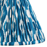 Close-up of Endon Brenwell 30cm tapered lamp shade in marlin blue, showing pleated faux silk with a blue and white ikat print and taped edge.