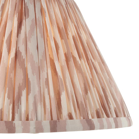 Close-up of Endon Brenwell 30cm tapered lamp shade in neutral, showing pleated faux silk with a soft pink and cream ikat print and taped edge.