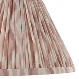Close-up of Endon Brenwell 30cm tapered lamp shade in neutral, showing pleated faux silk with pink ikat print and taped edge trim.