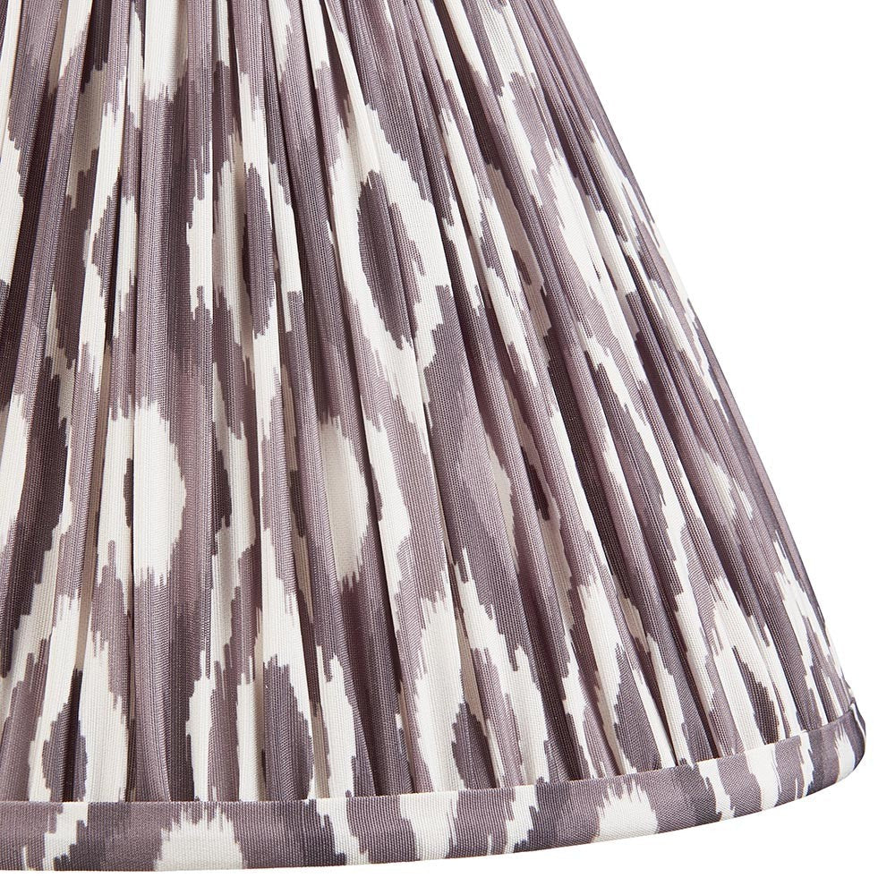 Close-up of Endon Brenwell 30cm tapered lamp shade in pearl grey, showing pleated faux silk with ikat pattern and taped bottom edge.