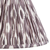 Close-up of Endon Brenwell 30cm tapered lamp shade in pearl grey, showing pleated faux silk with ikat pattern and taped bottom edge.