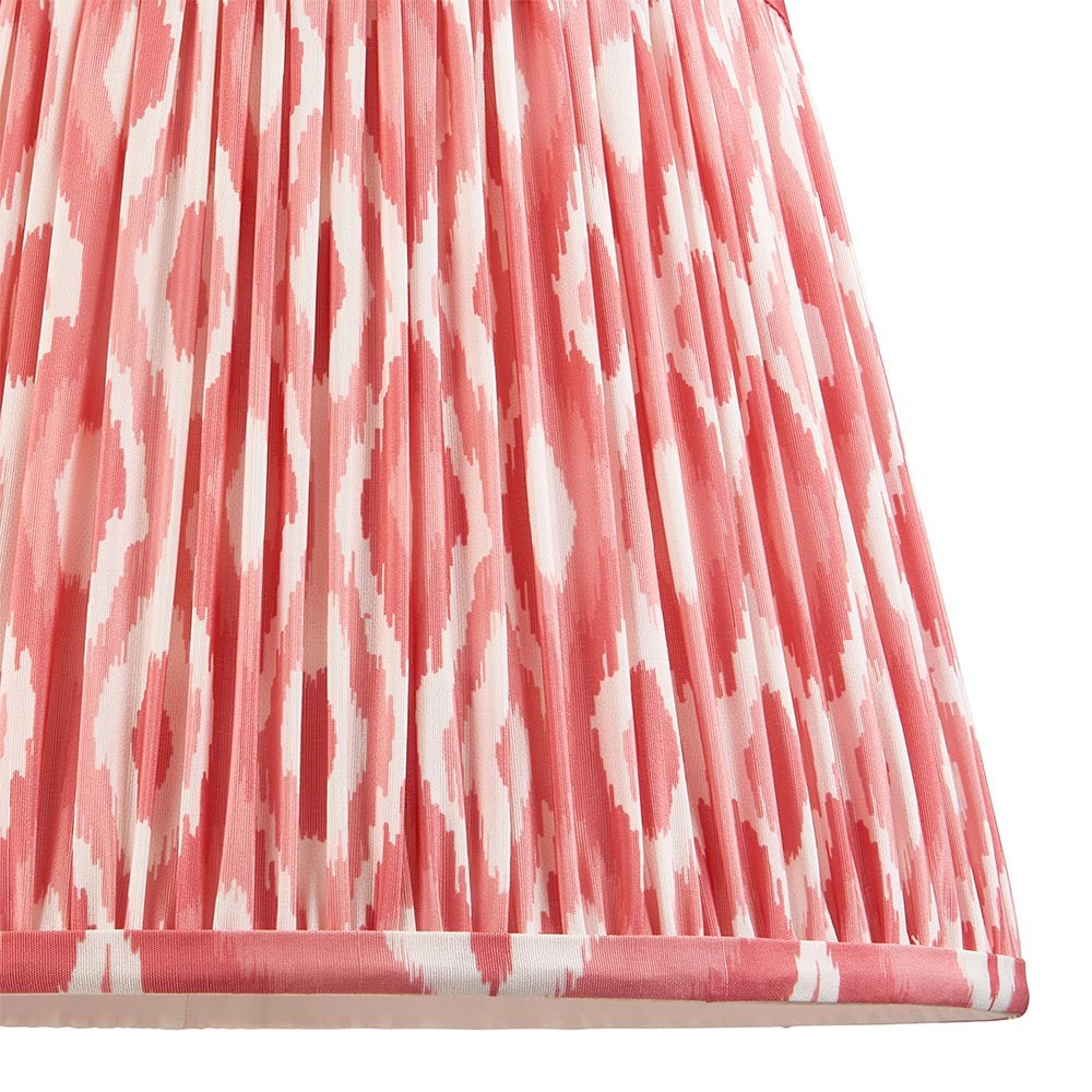 Close-up of Endon Brenwell 35cm tapered lamp shade in coral pink and white ikat print on pleated faux silk with taped edge detailing.