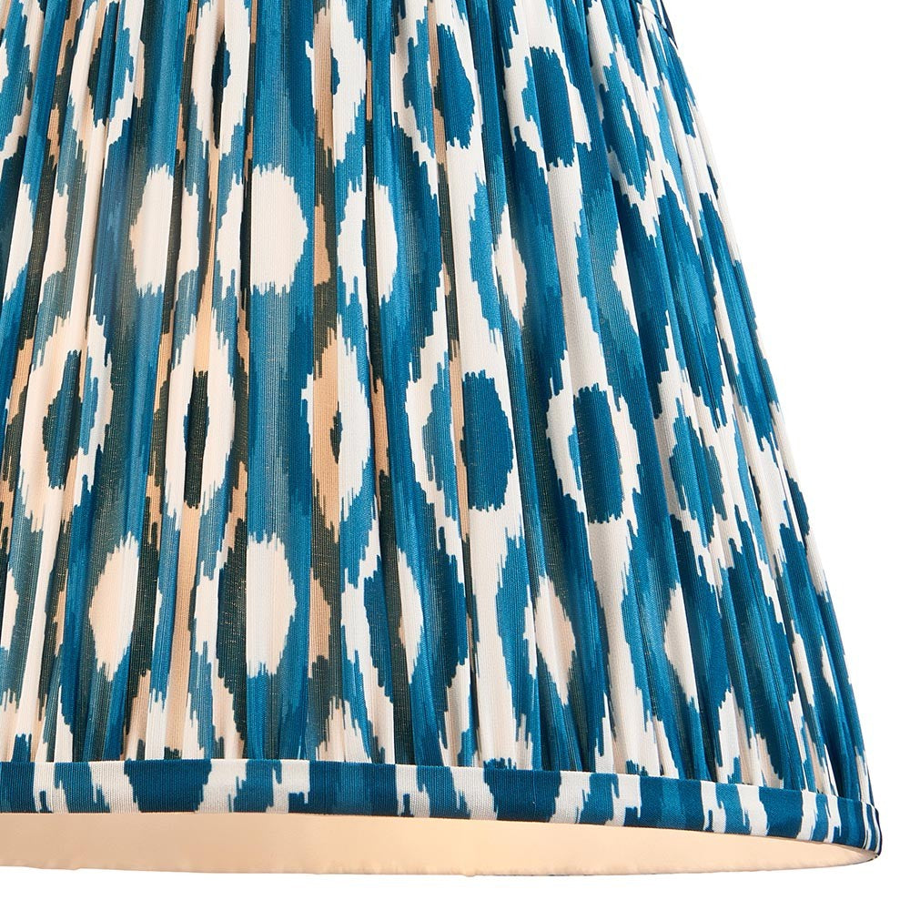 Close-up of Endon Brenwell 35cm tapered lamp shade in marlin blue, showing pleated faux silk with a blue and white ikat pattern and taped edging.