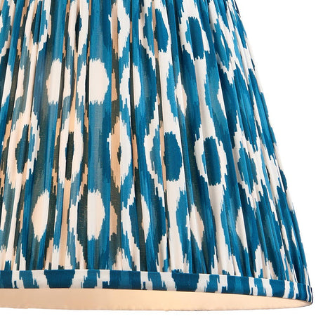 Close-up of Endon Brenwell 35cm tapered lamp shade in marlin blue, showing pleated faux silk with a blue and white ikat pattern and taped edging.