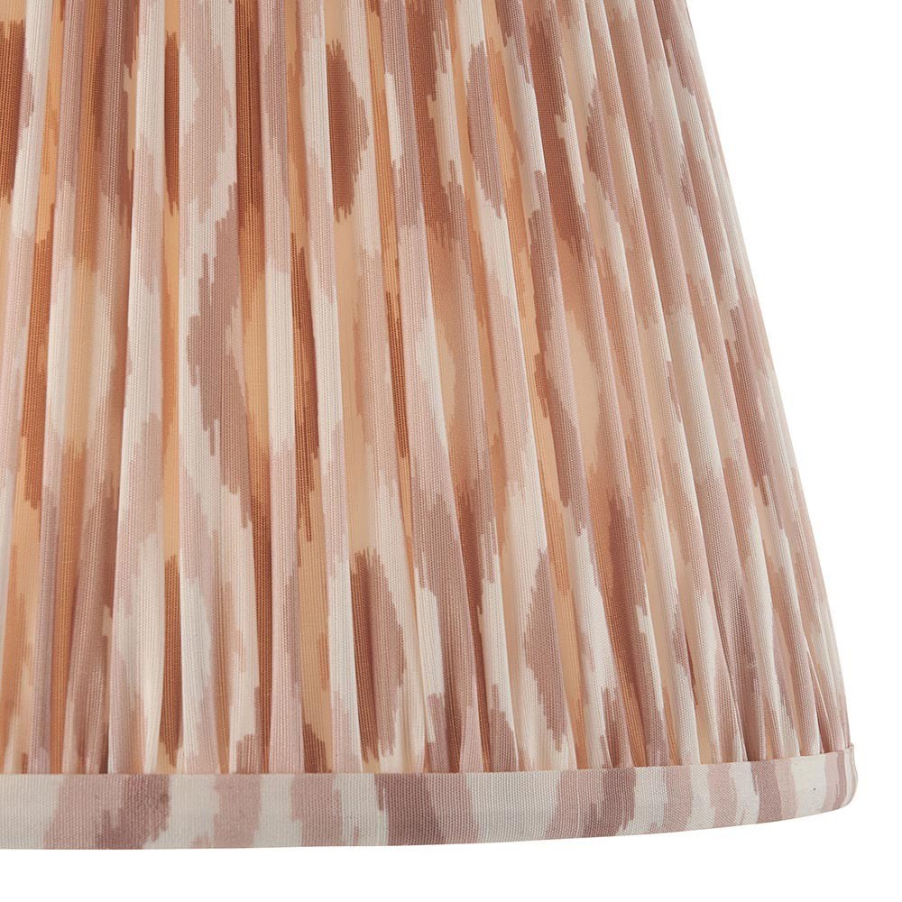 Close-up of Endon Brenwell 35cm tapered lamp shade in neutral, showing pleated faux silk with a soft pink and cream ikat print and taped edge trim.