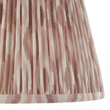 Close-up of the Endon Brenwell 35cm tapered lamp shade in neutral, showing pleated faux silk with a soft pink ikat print and taped edge trim.