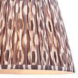 Endon Brenwell 35cm tapered lamp shade in pearl grey pleated faux silk with an ikat pattern in grey, brown and cream, shown in close-up.
