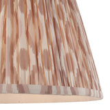 Close-up of Endon Brenwell 40cm tapered lamp shade in neutral, showing gathered pleated faux silk with a soft pink and cream ikat print and taped edge.