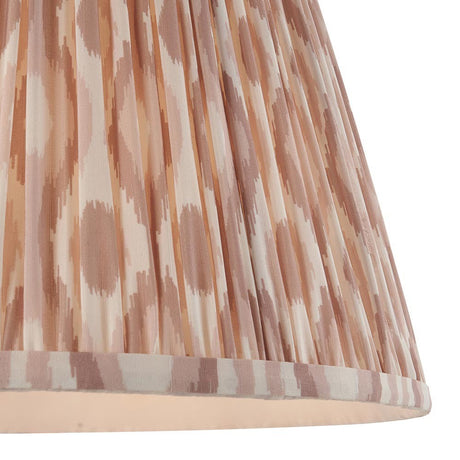 Close-up of Endon Brenwell 40cm tapered lamp shade in neutral, showing gathered pleated faux silk with a soft pink and cream ikat print and taped edge.