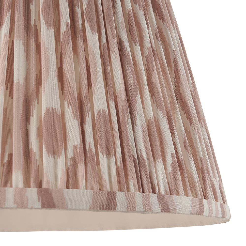 Close-up of Endon Brenwell 40cm tapered lamp shade in neutral, showing pleated faux silk with a pink and cream ikat print and taped edge.
