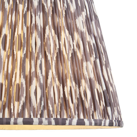 Close-up of Endon Brenwell 40cm tapered lamp shade in pearl grey, showing gathered pleated faux silk with ikat pattern and taped edge trim.
