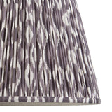 Close-up of Endon Brenwell 40cm tapered lamp shade in pearl grey, showing gathered pleated faux silk with an ikat pattern and taped edge detail.