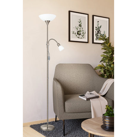 Brilbette Mother and Child Floor Lamp in satin nickel with a white bowl uplighter and adjustable gooseneck reading light, shown beside an armchair in a living room.