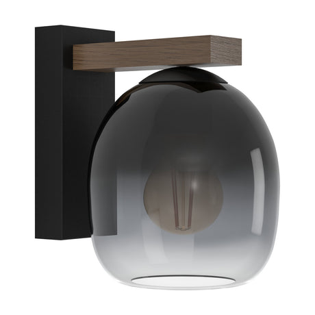 Brinvelle Wall Light with a black back plate, short brown wooden arm, and rounded smoked glass shade fading from dark grey to clear, shown with an exposed bulb on a plain white background.