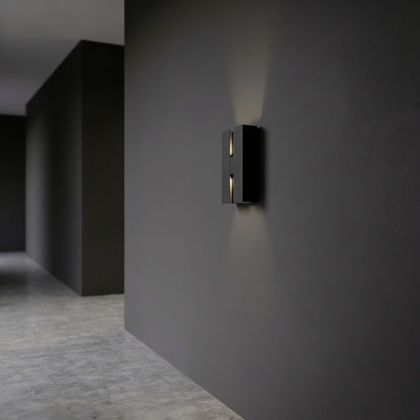 Briscola LED Outdoor Wall Light in black steel, a slim rectangular fixture with a vertical slot casting up and down light on a dark corridor wall, IP44 rated.