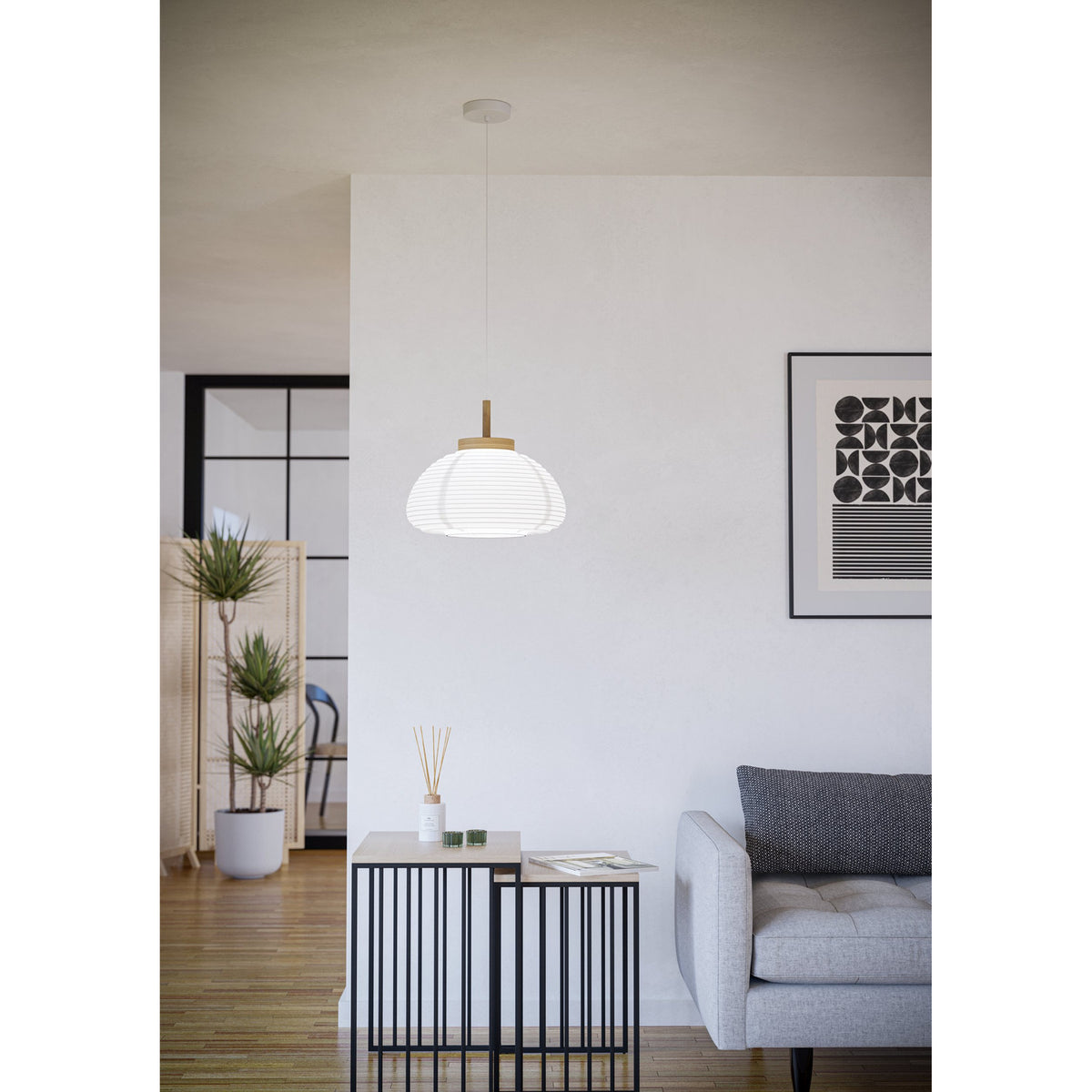 Brosmena Paper Pendant Light 55cm in white ribbed paper with a light wood collar and stem, hung on a white cord in a living room with a grey sofa and side table.