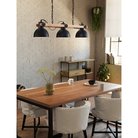 Brosora Linear Pendant Light in black steel and wood, three black dome shades on a wooden beam, hung above a dining table in a brick-walled room.