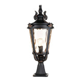 The Baltimore 1 Light Large Pedestal Lantern in a weathered bronze finish boasts a glass enclosure, decorative top, and glowing light bulb. This traditional outdoor lantern is elegantly mounted on a sturdy base and adorned with bronze accents.