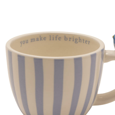 Cream stoneware mug with blue vertical stripes and a mini bird perched on the handle, "you make life brighter" printed inside the rim, on a white background.