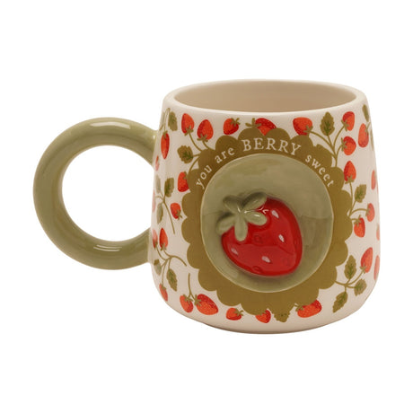 Cream earthenware mug with a 3D red strawberry medallion in a sage green scalloped circle, "you are BERRY sweet" text, strawberry print body, and a round green handle, shown on a white background.