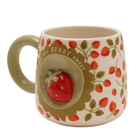 Cream earthenware mug with a raised red 3D strawberry medallion, "you are BERRY sweet" text, green handle, and strawberry print, shown on a white background.