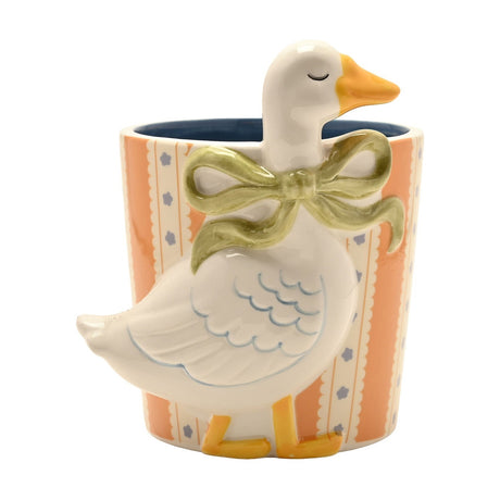 Round ceramic planter in orange and cream stripes with a raised white goose and green bow, blue glazed interior, on a plain white background.