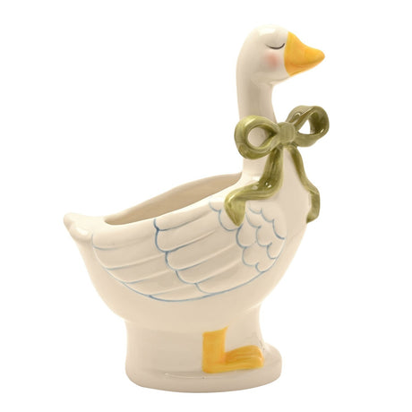 Cream ceramic goose planter with closed eyes, yellow beak and feet, blue-lined wing detail, and a sage green bow at the neck, on a plain white background.