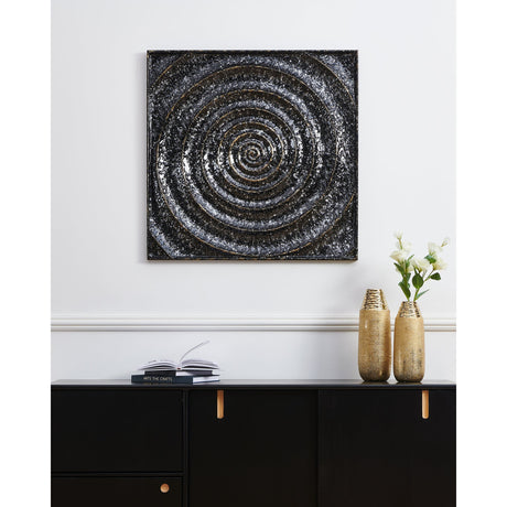 Bugrino Wall Decoration 81.5 x 2.5cm, a square black metal panel with a raised spiral texture and gold line detailing, shown above a black sideboard with gold vases in a living room.