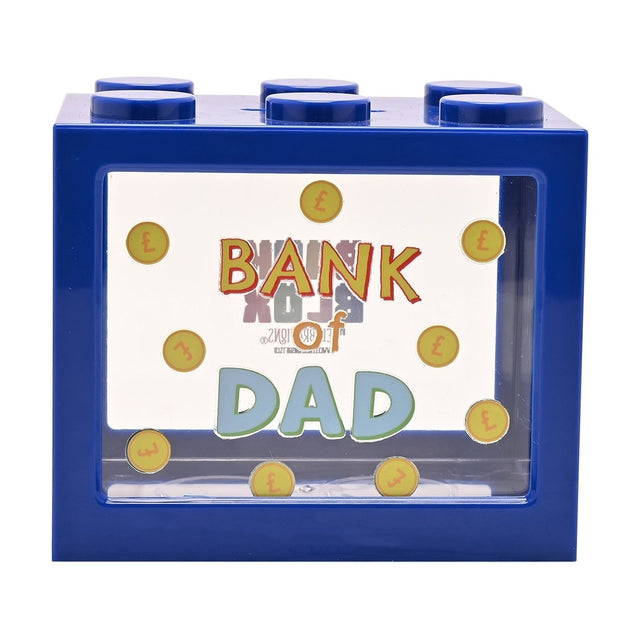 Navy blue plastic building block money box with six top studs and a clear front window showing "Bank of Dad" lettering surrounded by gold pound-sign coins, on a plain white background.
