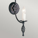 The Belfry 1 Light Wall Light - Black exudes old-world charm with its decorative twisted base and single bulb. Its flower-like backplate design enhances its medieval elegance, while the candle-like bulb adds an elegant touch to vintage-inspired interiors.