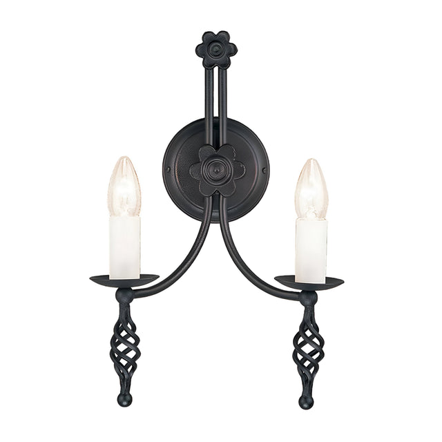 The Belfry 2 Light Wall Light in black highlights medieval craftsmanship with its wrought-iron construction, featuring hand-forged floral and geometric elements. It includes two candle-shaped light bulbs designed to mimic traditional candles, providing a symmetrical design that infuses any room with timeless elegance.