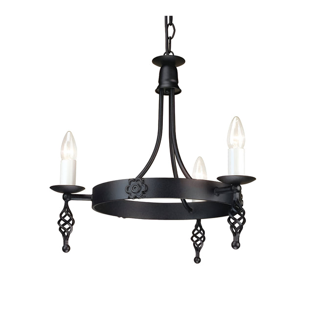 The Belfry 3 Light Chandelier - Black showcases medieval craftsmanship with its black metal design. It features three candle-shaped bulbs resting on spiral holders, all suspended from a hand-forged metal frame adorned with decorative floral details and a sturdy chain attachment.