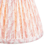 Close-up of the Caldgrove 16cm tapered lamp shade in Peachy Keen, showing pleated faux linen fabric with a leaf pattern and taped edge trim.