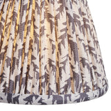Close-up of Endon Caldgrove 16cm tapered lamp shade in pearl grey, showing pleated faux linen with a grey leaf print and taped lower edge.