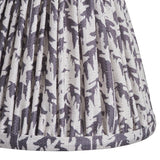 Close-up of Endon Caldgrove 16cm tapered lamp shade in pearl grey, showing pleated faux linen with a soft leaf print and taped edge detail.