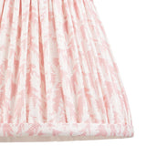 Close-up of Endon Caldgrove 20cm tapered lamp shade in Peachy Keen, showing gathered pleated faux linen with a soft pink leaf print and taped edge.