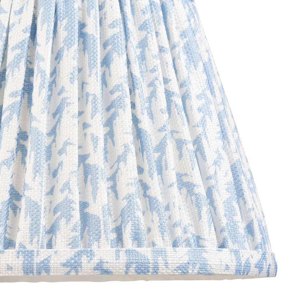 Close-up of Endon Caldgrove 20cm tapered lamp shade in Shell Bay Blue, showing pleated faux linen with a blue and white leaf print and taped edge.
