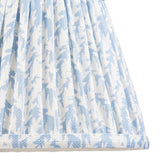 Close-up of Endon Caldgrove 20cm tapered lamp shade in Shell Bay Blue, showing pleated faux linen with a blue and white leaf print and taped edge.