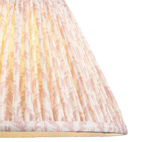 Close-up of the Endon Caldgrove 30cm tapered lamp shade in Peachy Keen, showing pleated faux linen with a soft pink leaf print and taped edging.