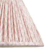Close-up of the Endon Caldgrove 30cm tapered lamp shade in Peachy Keen, showing pleated faux linen with a soft pink leaf print and taped edge.