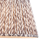 Endon Caldgrove 35cm tapered lamp shade in pearl grey faux linen, close-up of the pleated leaf-print fabric with taped edge detailing along the bottom.