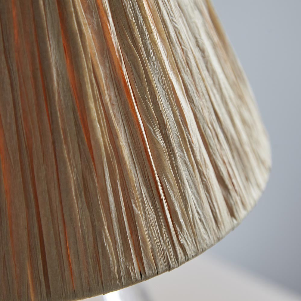 Close-up of the Caldwood 25cm tapered lamp shade in natural raffia, showing hand-wrapped woven texture in earthy brown tones against a light grey background.