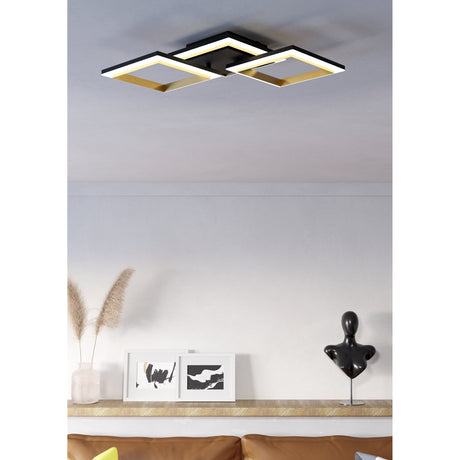 Calliera LED flush ceiling light with three linked square frames in black and brass finish, mounted on a white ceiling above a living room with framed art and decor.