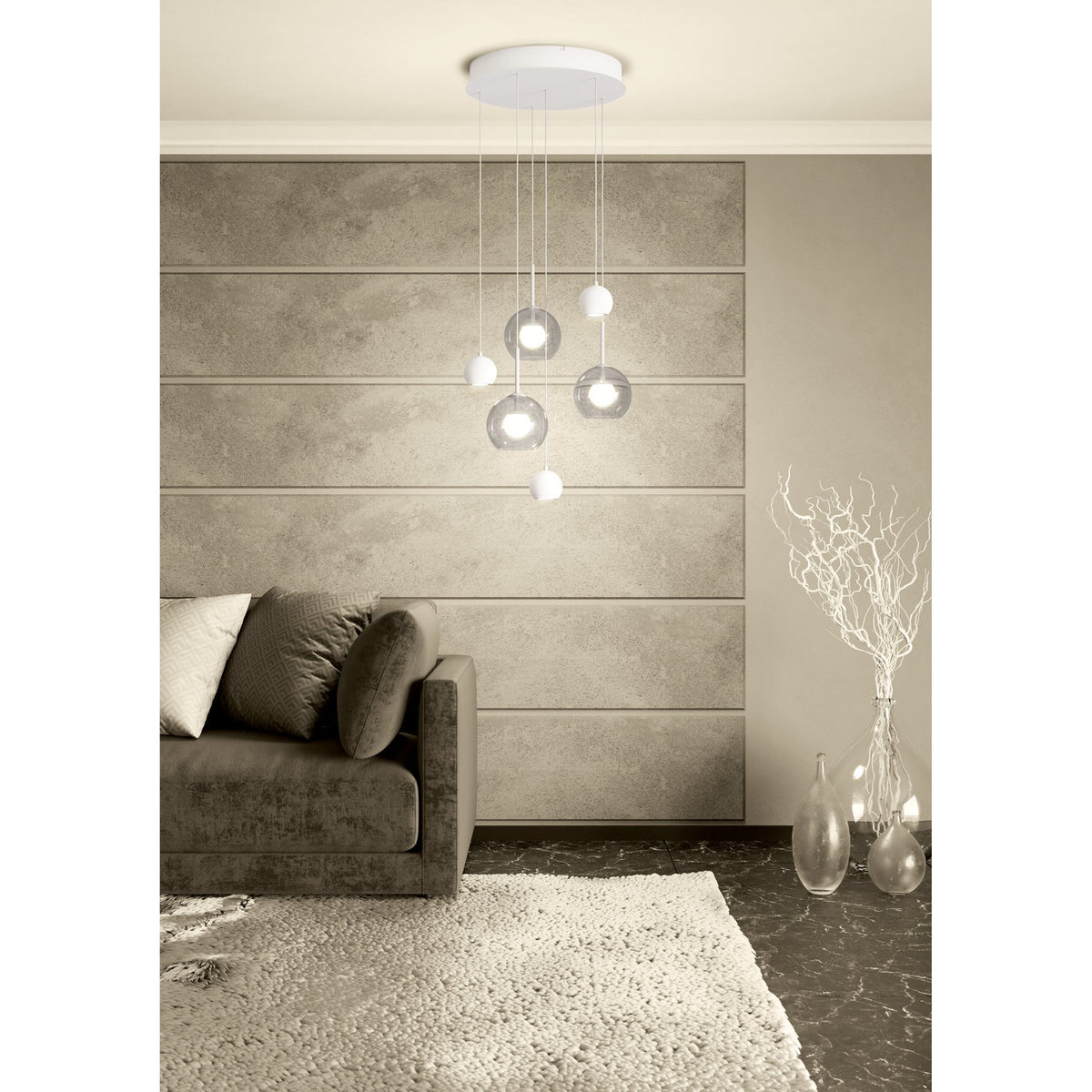 Caprecano 6-Light Pendant in white, with round ceiling plate, white ball shades and clear glass globes at staggered heights, shown above a sofa in a living room.