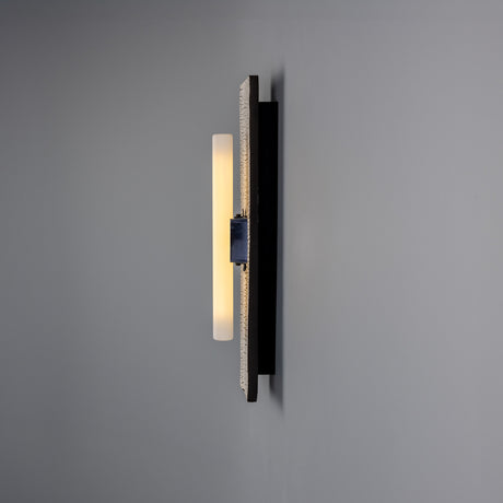 Capua Ceramic Wall Light in Black Clay, a slim upright crackled-glaze panel on a matt black backplate with a visible S14d tube light source, shown against a plain grey background.