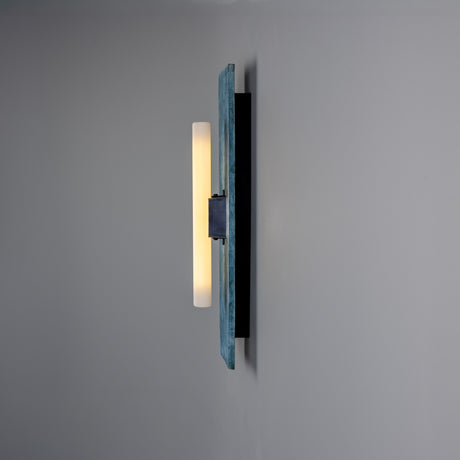 Capua Ceramic Wall Light in Blue Earth glaze, side view showing the tall ceramic plate with a lit S14d tube bulb on a black bracket, mounted on a plain grey wall.