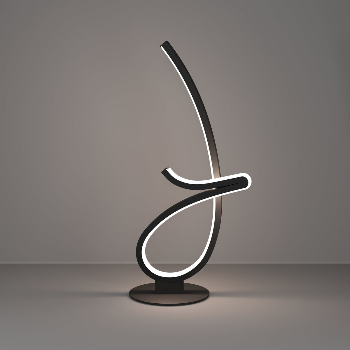 Cardoncito LED Table Lamp in black steel, a looping ribbon form on a round disc base with an illuminated white diffuser edge, shown against a plain grey background.