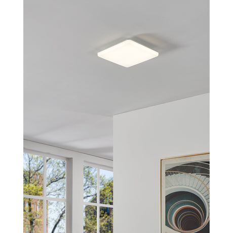 Castagneto LED Panel Light, a square 31 x 31cm white ceiling fixture with softly rounded corners, shown illuminated on a white ceiling in a bright room.