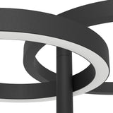 Close-up of the Castelpoto 1 LED floor lamp in black, showing intersecting steel rings with white plastic shades around the central pole on a plain background.